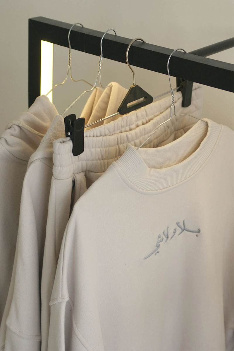 ivory sweatshirt hand-embroidered with lyrics fron Ziad Rahbani's song meaning without anything