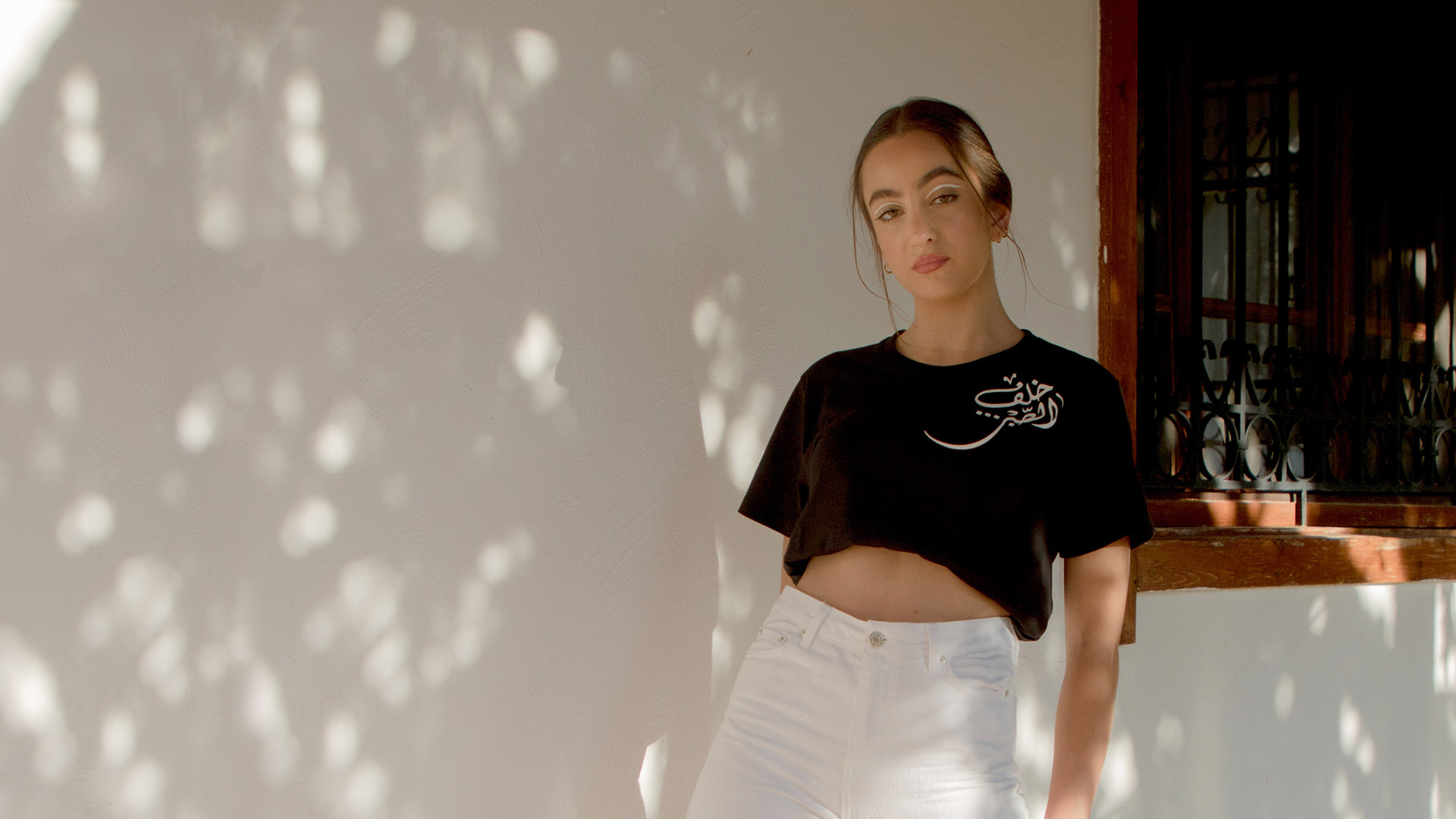 Beautiful Things black tshirt hand-painted with arabic calligraphy in white styled with our Faraya white denim jeans